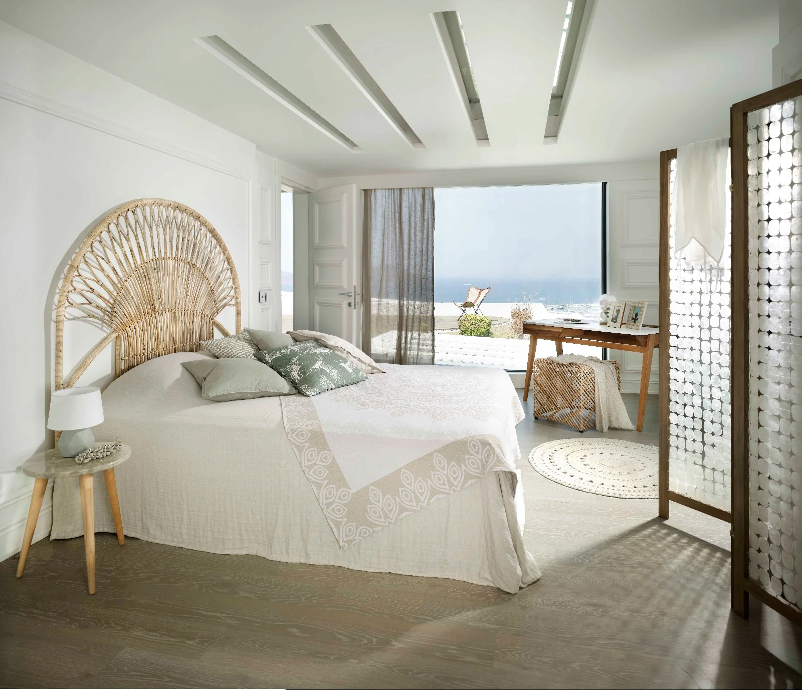 Sea View room with a rattan headboard, linen bedding and a large window facing the marina