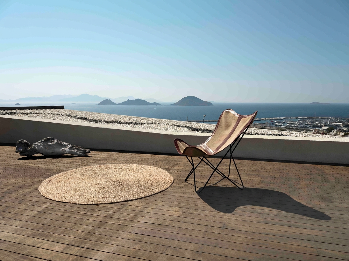 Sun deck of Marinhill Luxury Villas in Bodrum with a lounge chair overlooking the Aegean sea, marina and islands